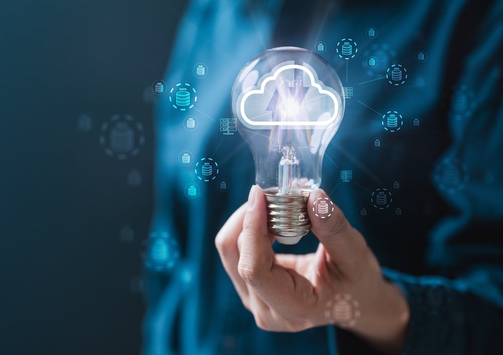 man holding light bulb with cloud icon inside. moving to the cloud concept.