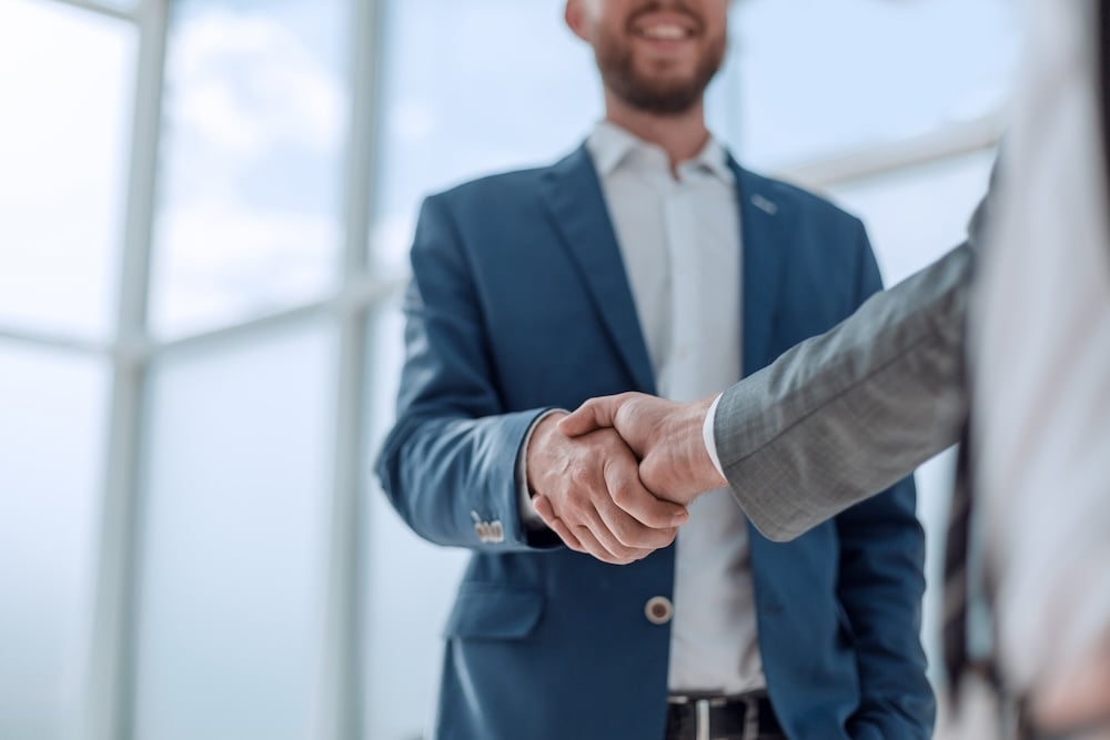 Two business people shaking hands. Managed IT partnership concept.