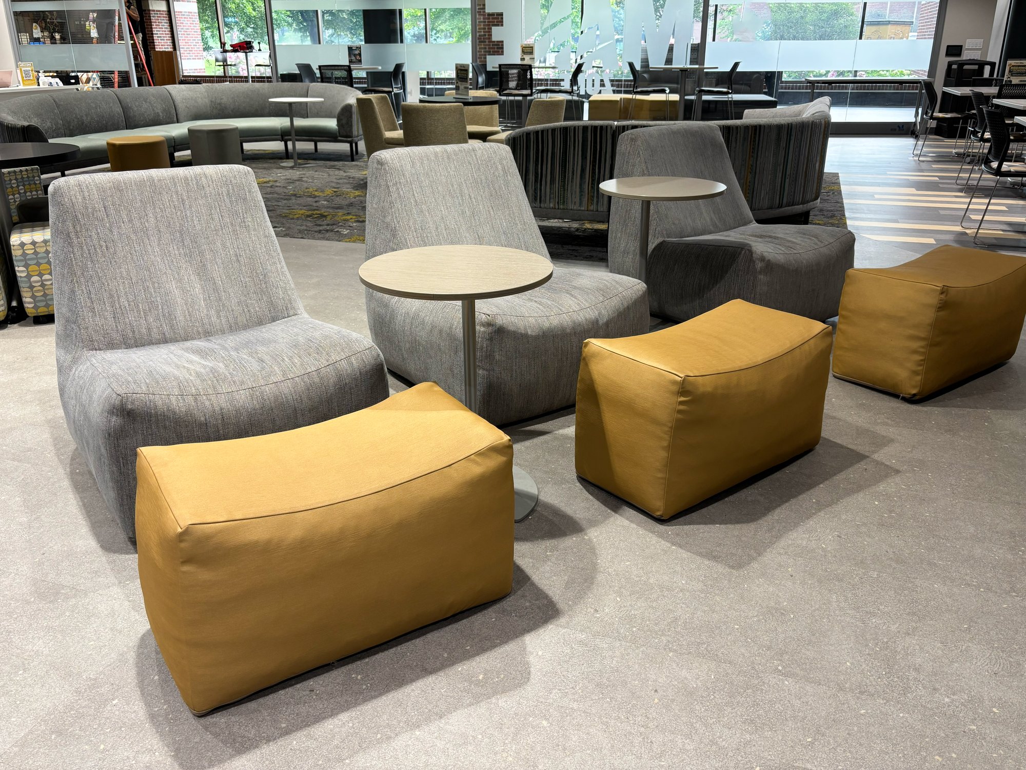 Three soft silver chairs with gold foot stools and tables in between Three soft silver chairs with gold foot stools and tables in between