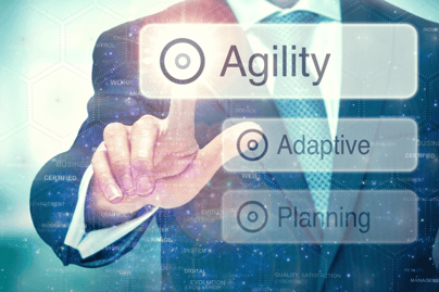 A c-suite executive clicking a button that says agility. Other buttons shown are adaptive, and planning.