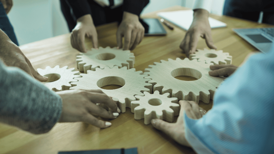 People putting wooden gears together on a conference table