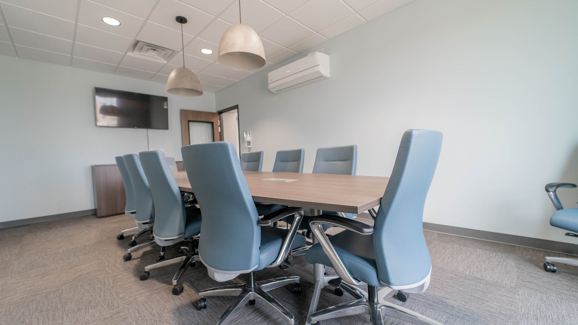 Conference room with a boat-shaped table and blue chairs Conference room with a boat-shaped table and blue chairs