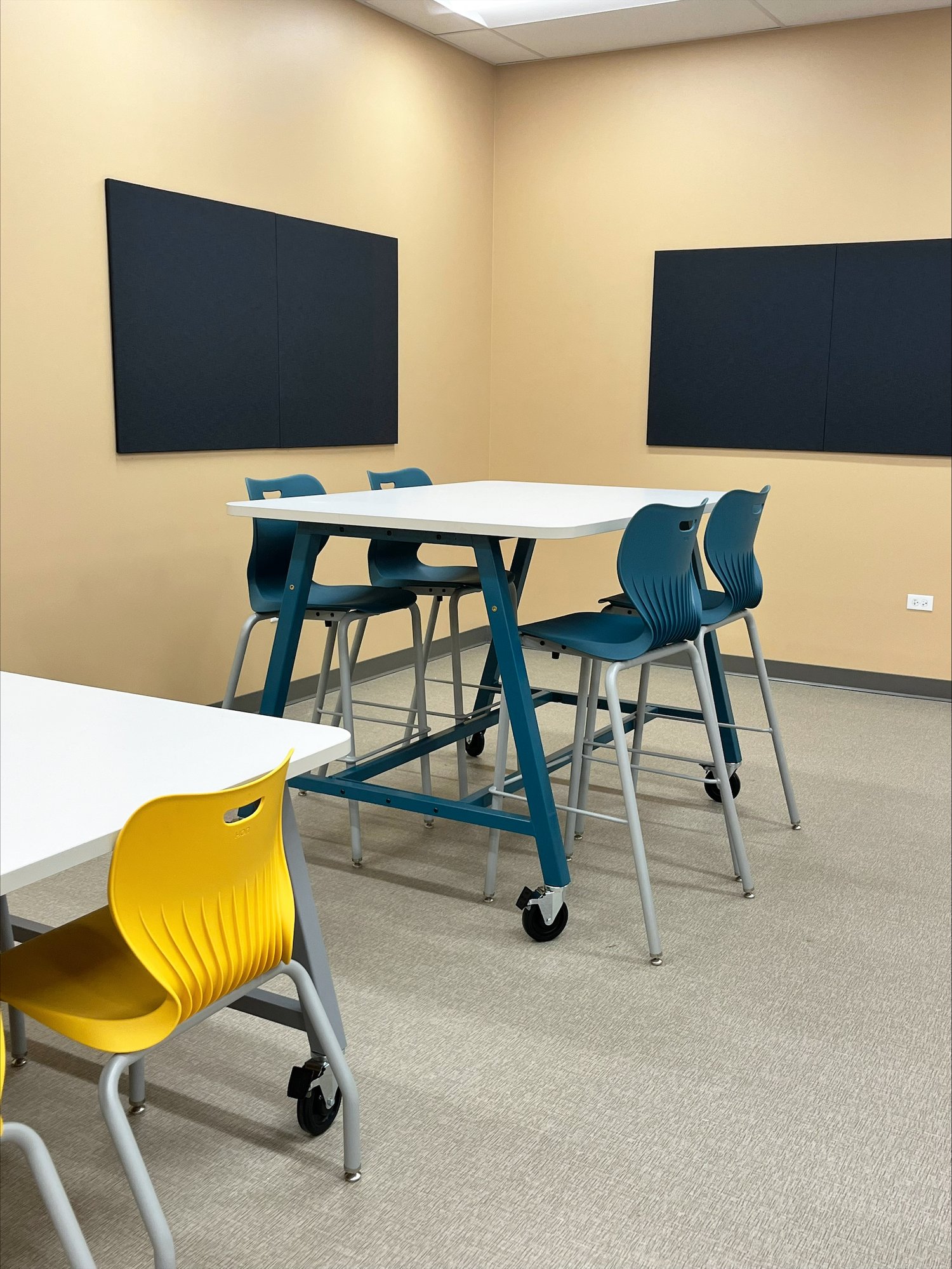 Table with stool-height, blue seats with two TVs mounted to the wall Table with stool-height, blue seats with two TVs mounted to the wall