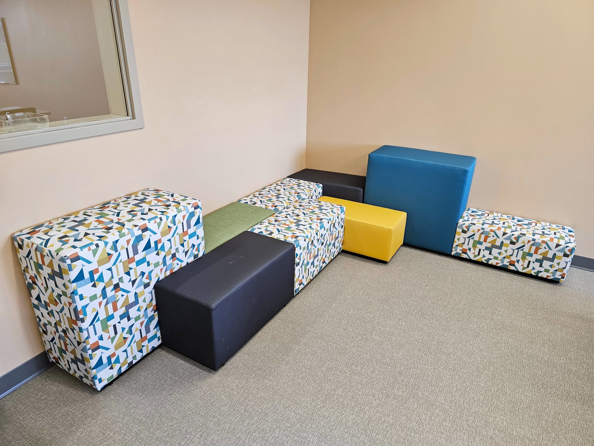 Hon Tangram rectangular, multi-colored cushions are arranged in a corner Hon Tangram rectangular, multi-colored cushions are arranged in a corner