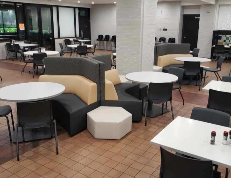 Angular couches with tables and chairs surrounding