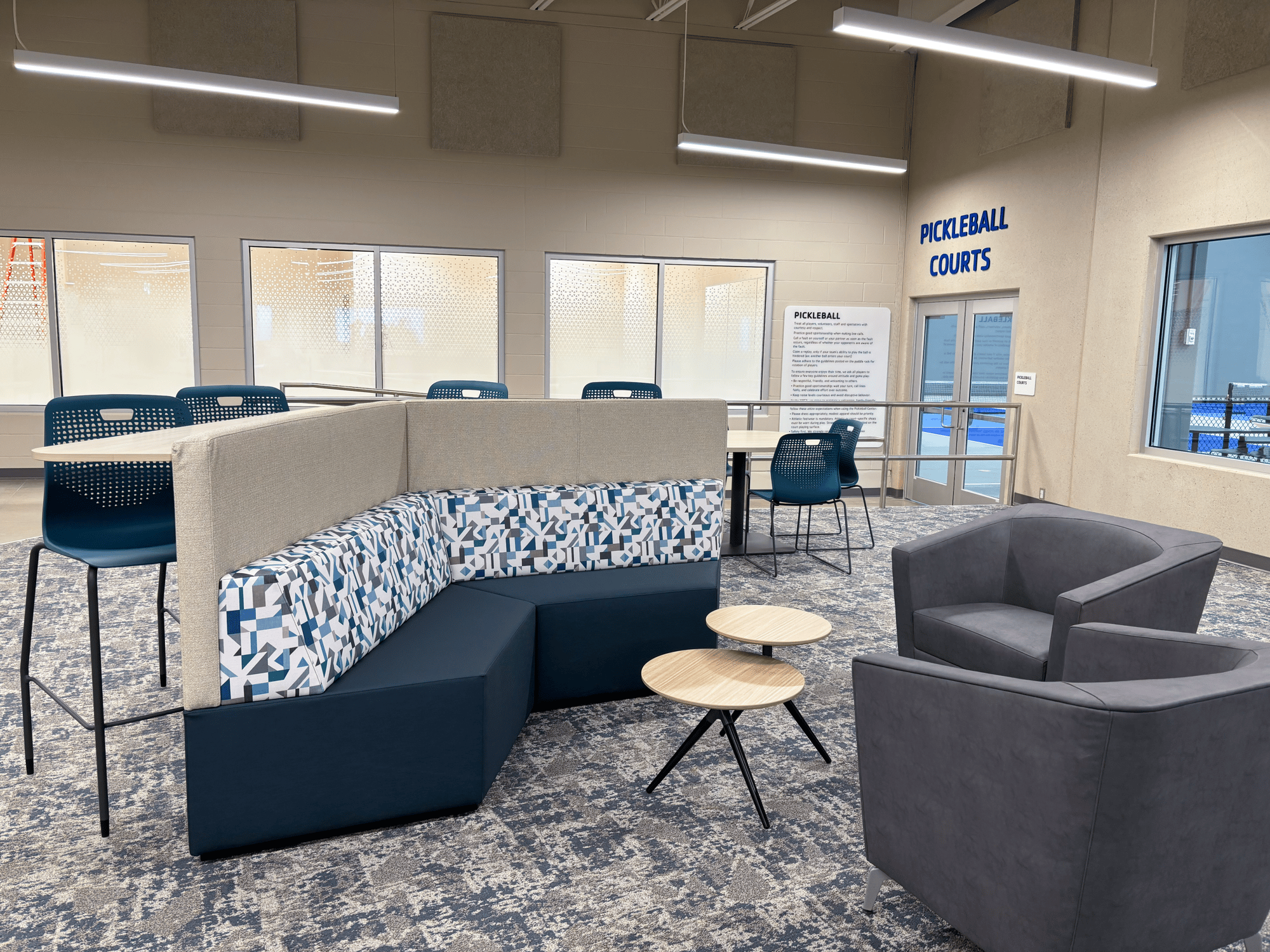 Angular couch and two lounge chairs flank a two-tier table Angular couch and two lounge chairs flank a two-tier table