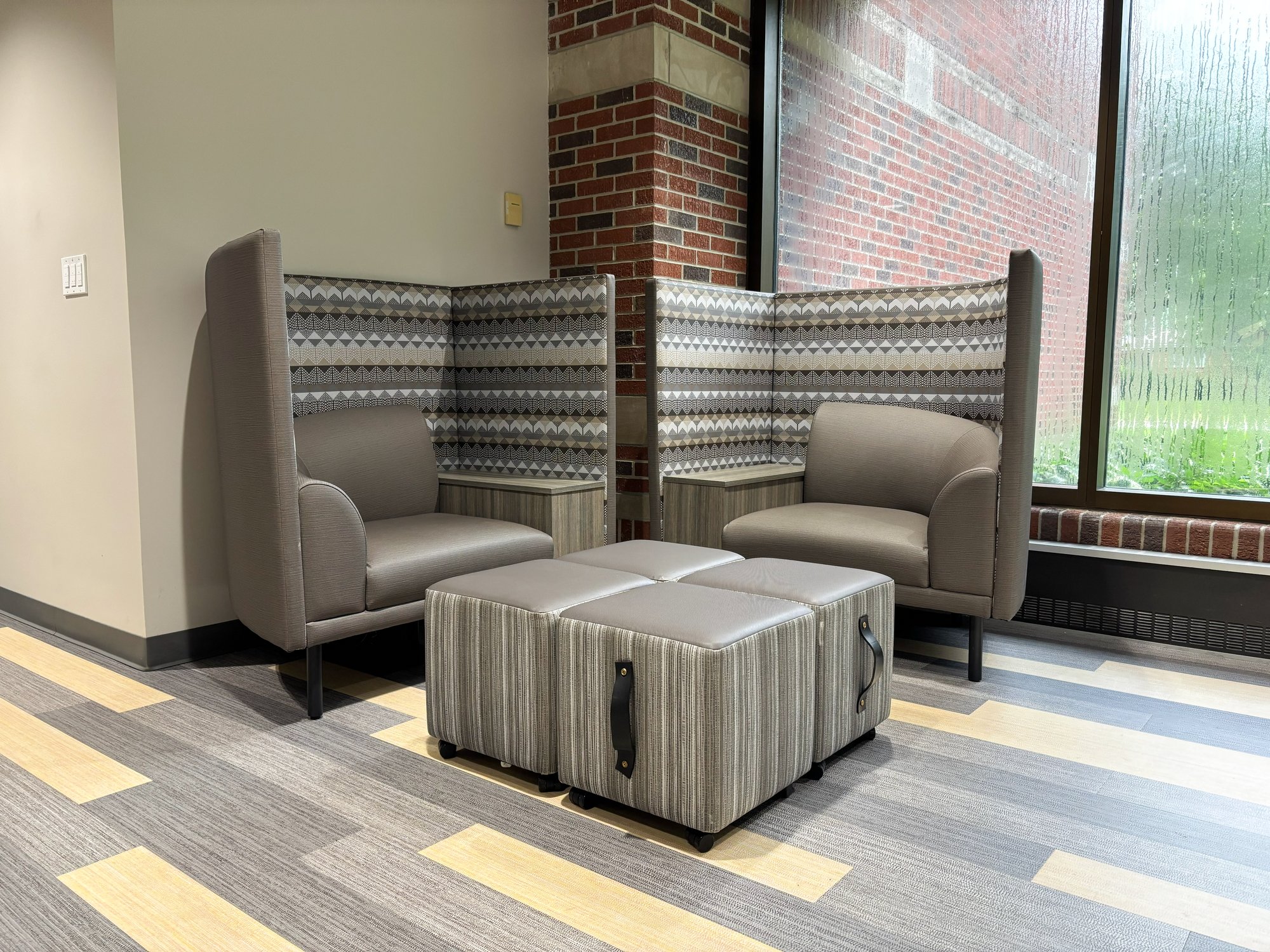 Soft seating with soft stools in shades of grey Soft seating with soft stools in shades of grey