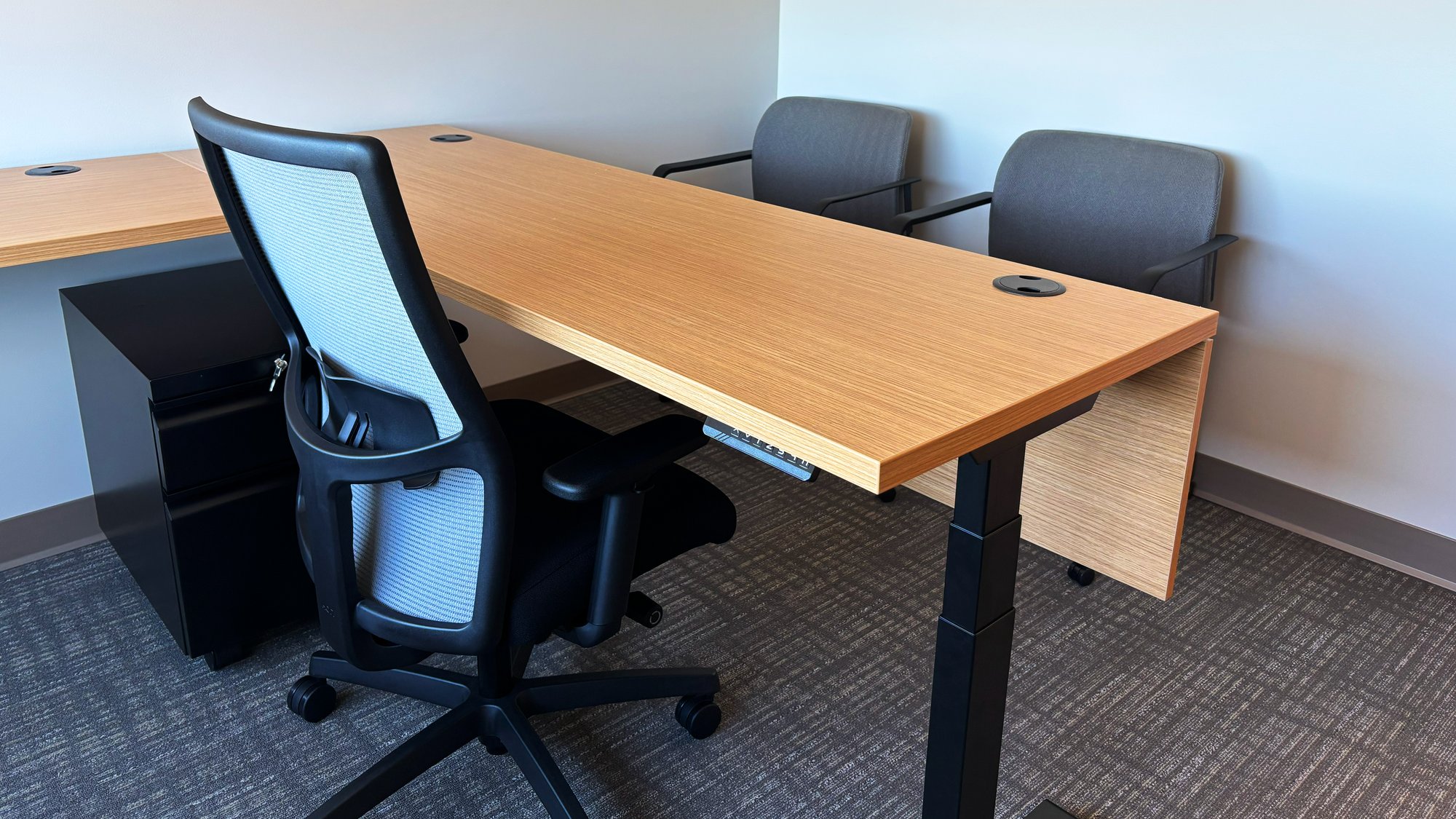 Personal office with one rolling chair, two stationary chairs, and a height-adjustable desk Personal office with one rolling chair, two stationary chairs, and a height-adjustable desk