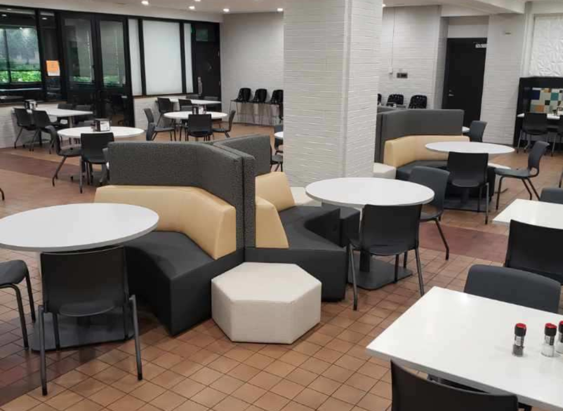 Angular couches with tables and chairs surrounding