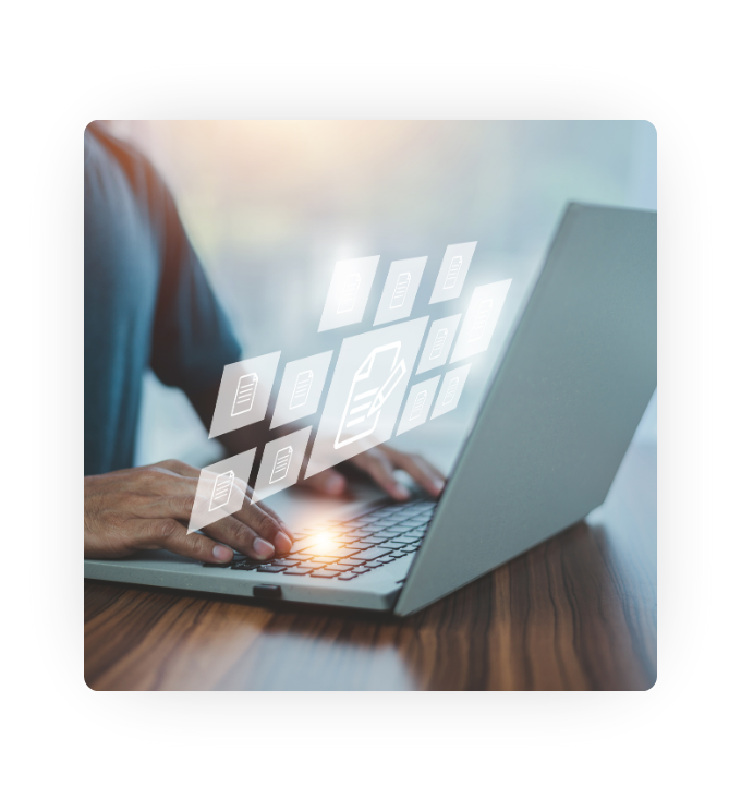 A person at a desk typing on a laptop with digital file icons floating over the keyboard. A person at a desk typing on a laptop with digital file icons floating over the keyboard.
