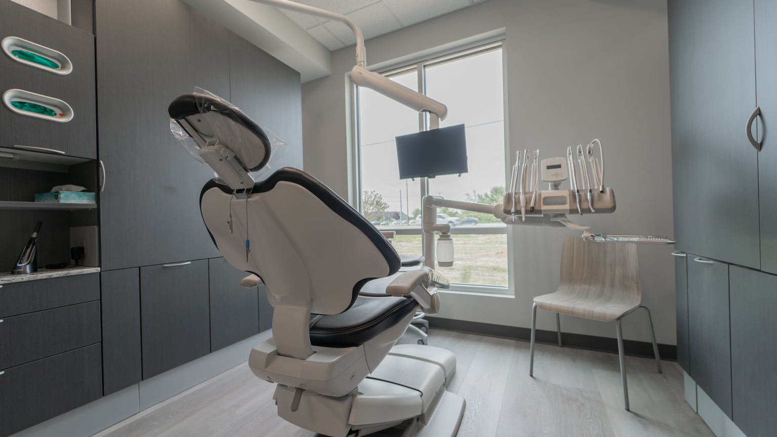 Exam room with dentist chair, stationary chair, and various storage options