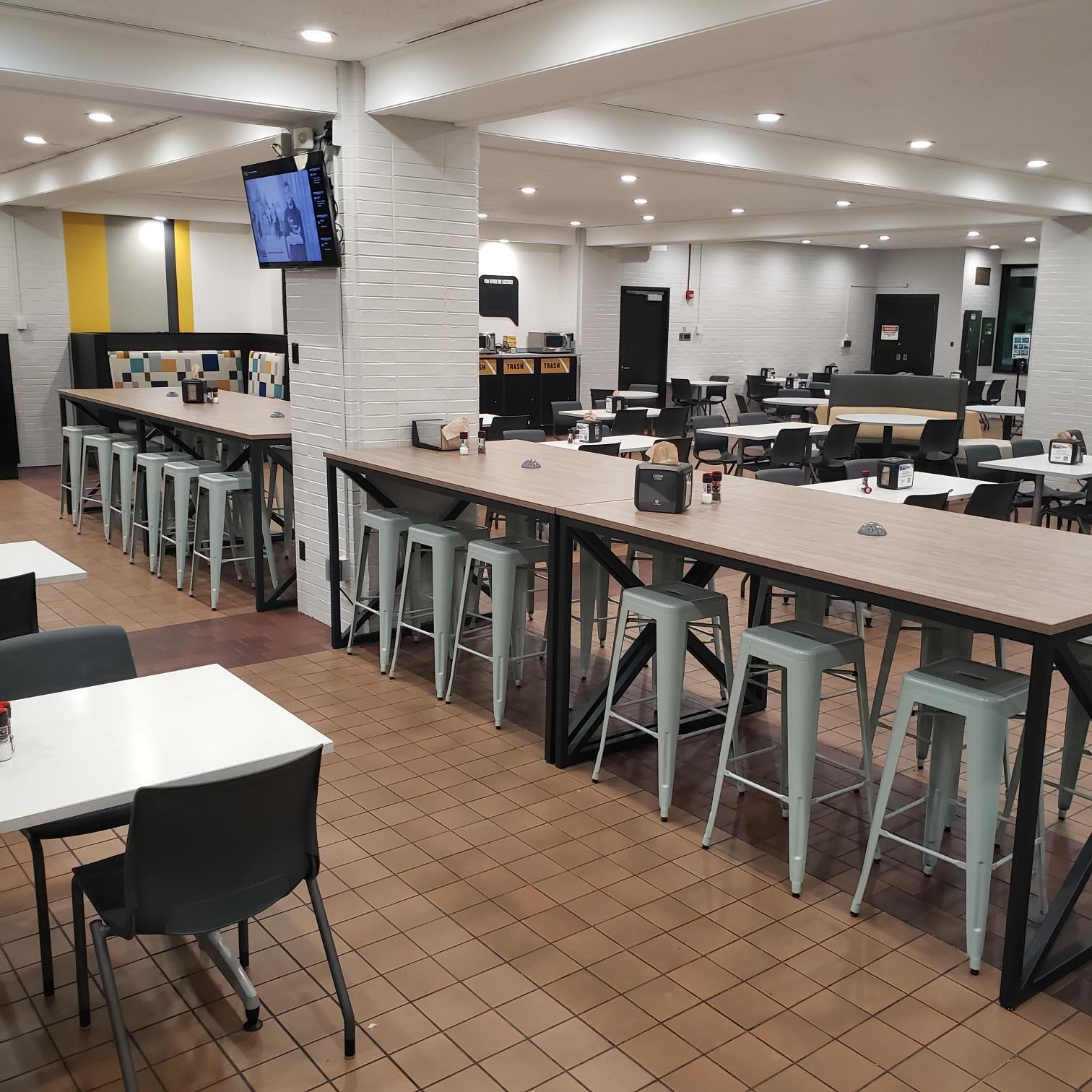 Large butcher-block counters with muted teal, metal stools beneath Large butcher-block counters with muted teal, metal stools beneath