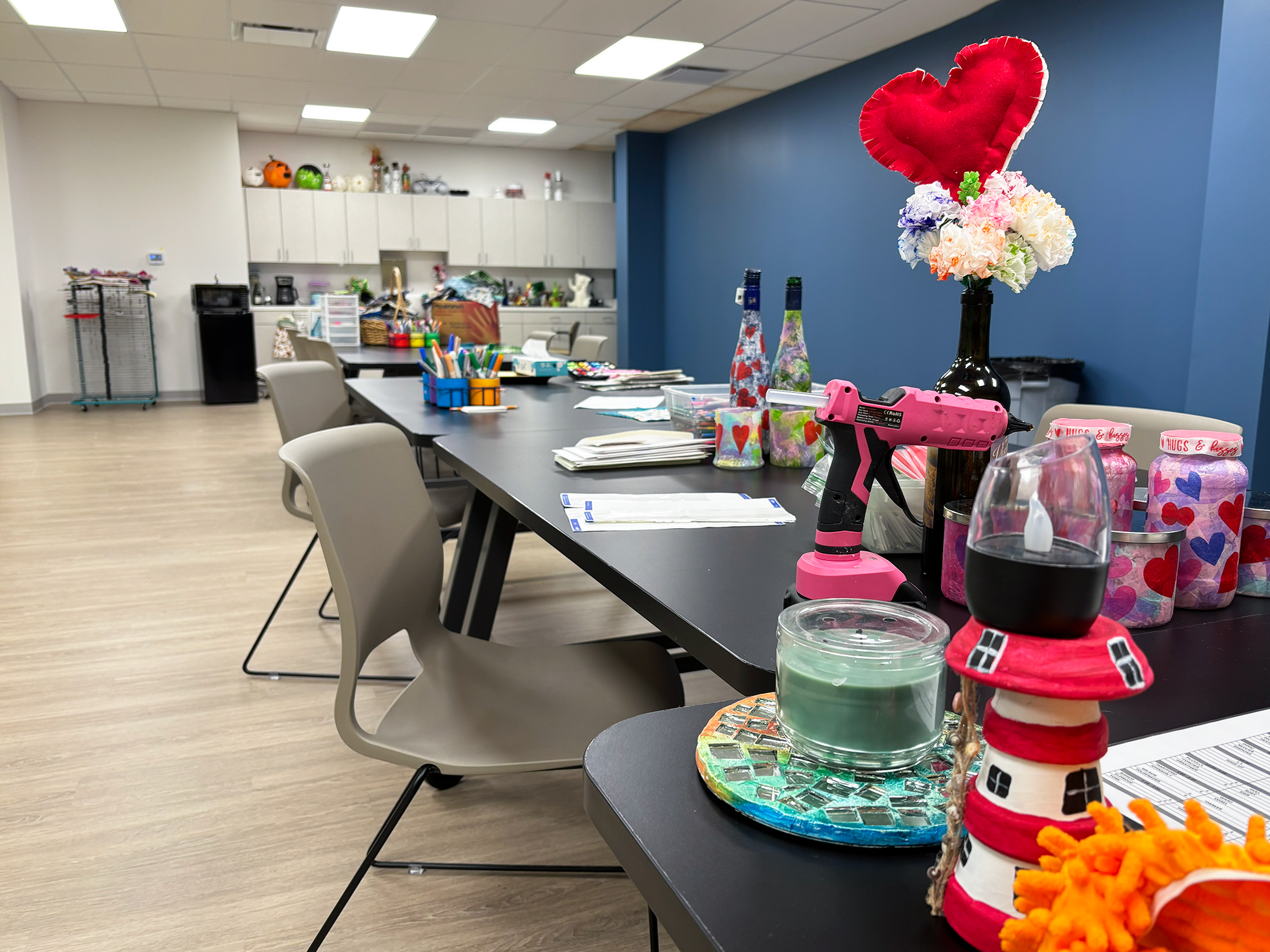 Chairs pushed up to tables covered in art supplies