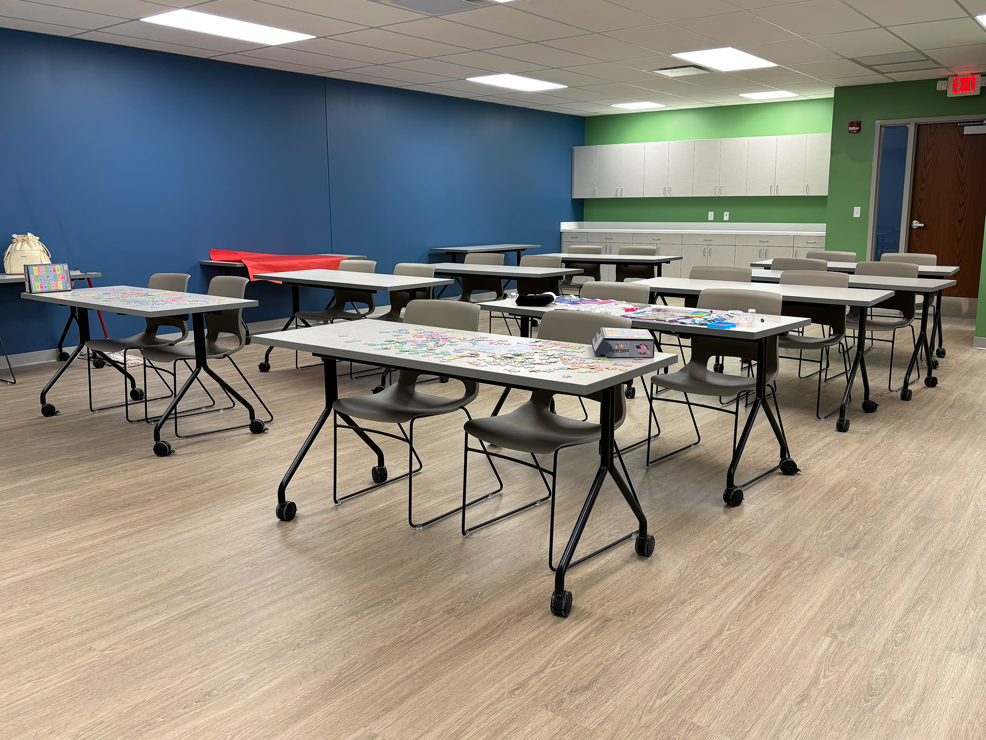 Rolling chairs are arranged in rows, with two chairs pushed up to each