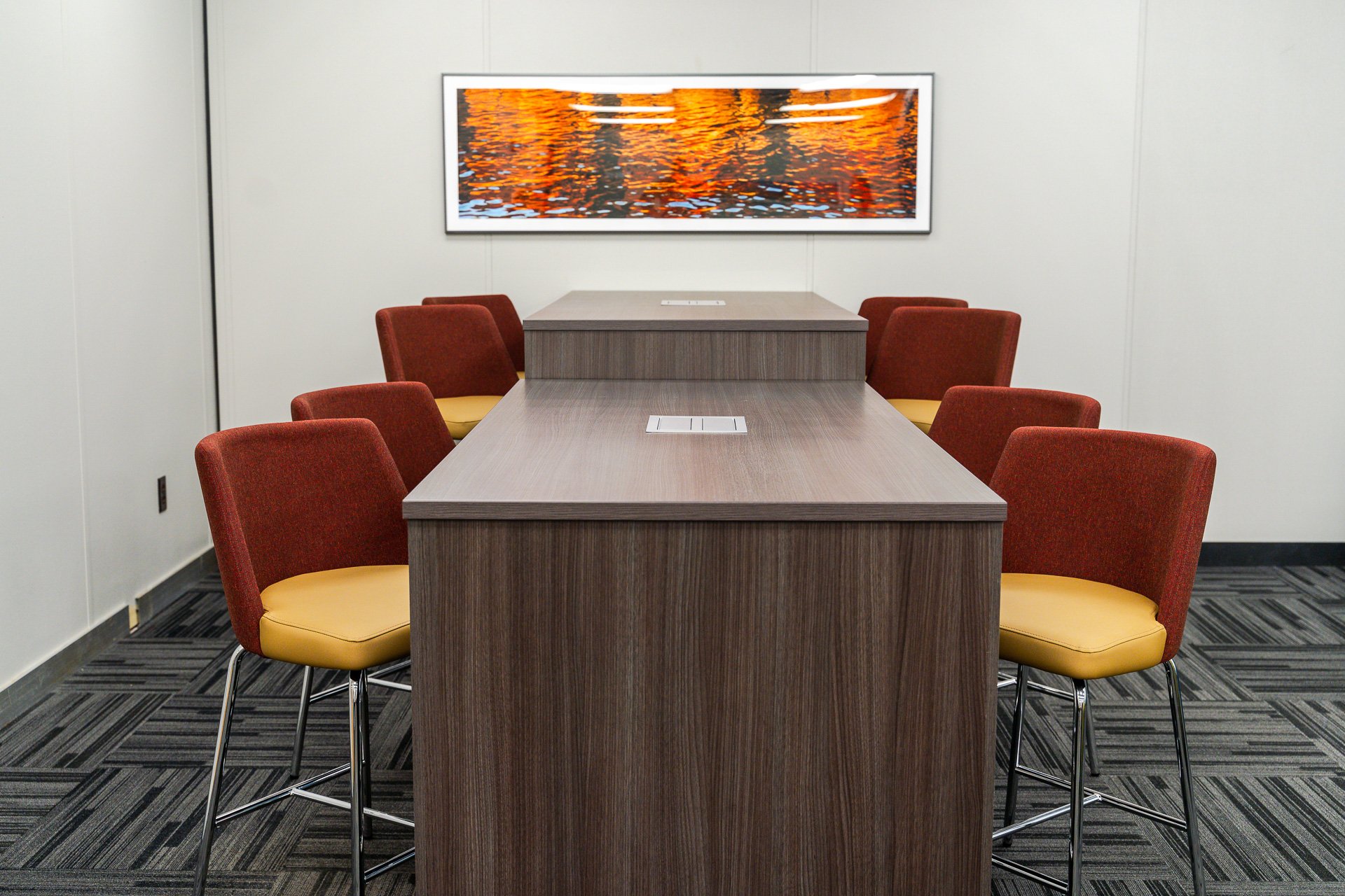 Multi-height table is surrounded by gold and red chairs Multi-height table is surrounded by gold and red chairs