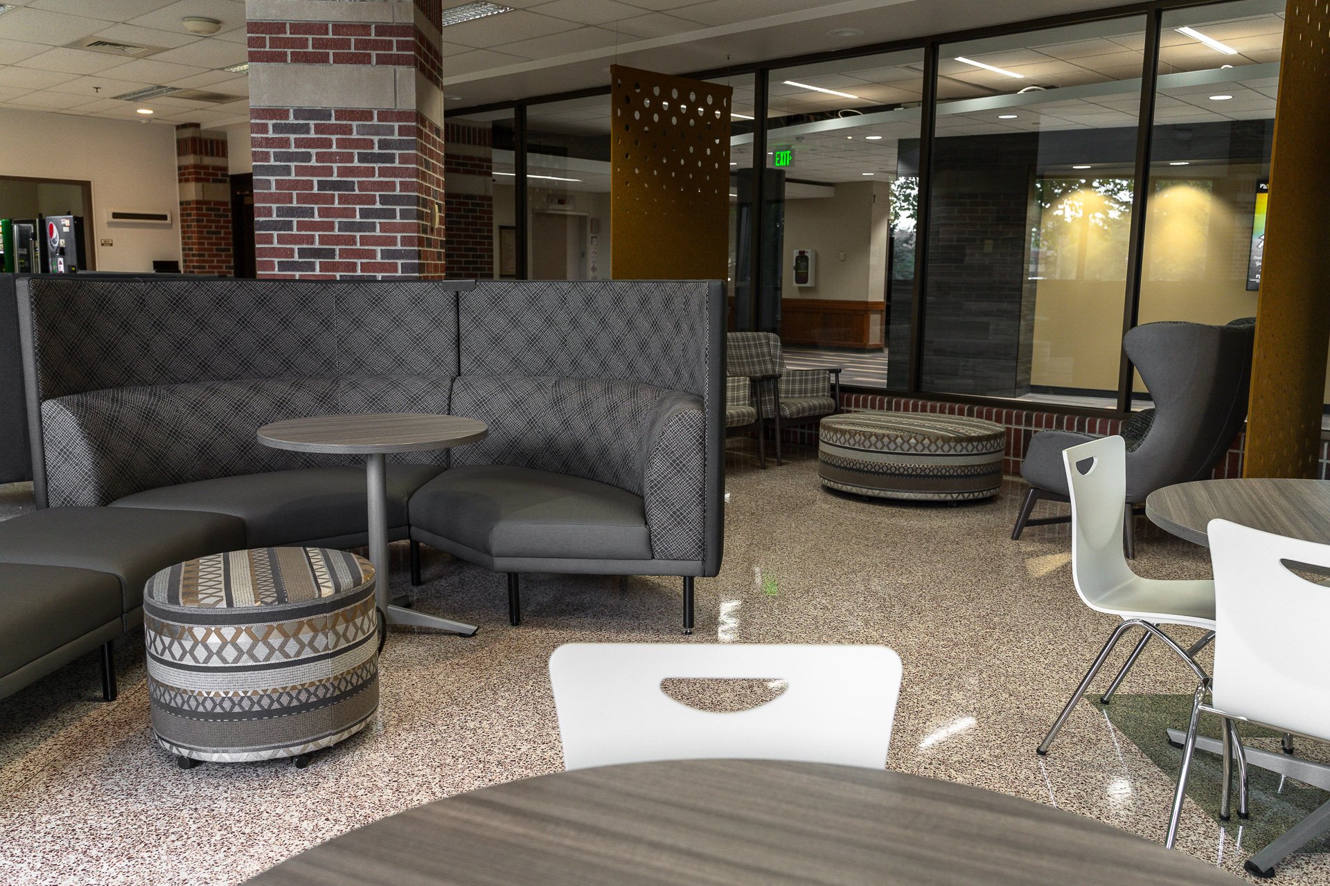Tall-back couch with tables, chairs, and ottomans surrounding. Tall-back couch with tables, chairs, and ottomans surrounding.
